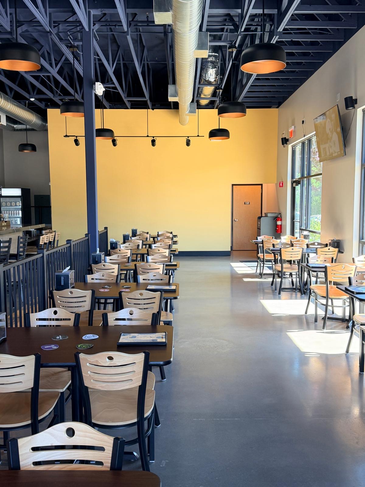 The dining room's gold feature wall under black steel and copper-lined pendants